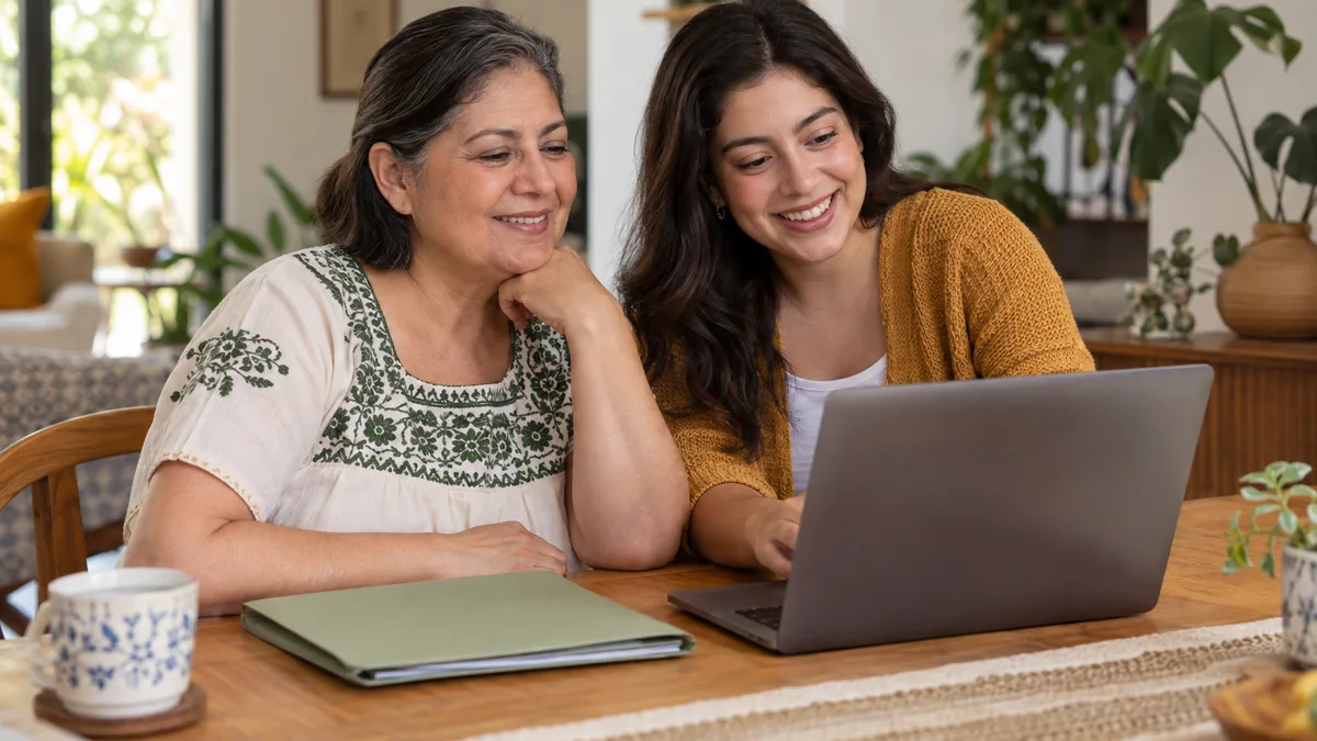 Madre e hija adulta preparando una carpeta de documentos en casa.